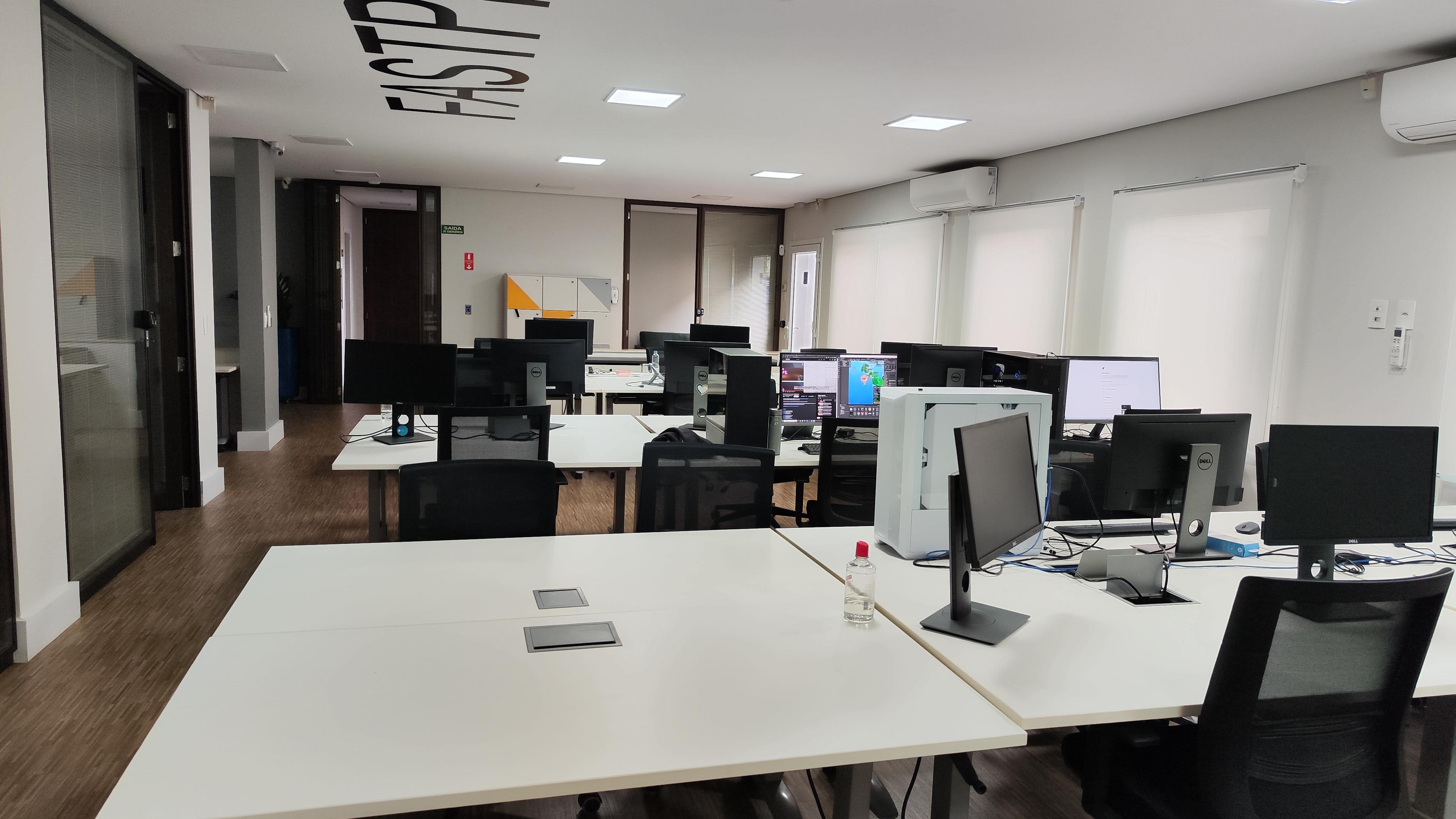 área do escritório da Fast3DLab, contendo mesas e computadores.